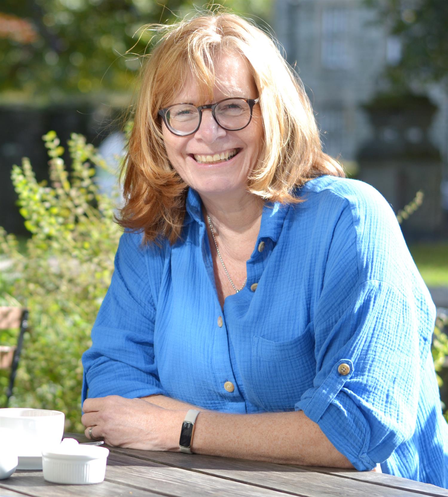 A lady sitting outside and smiling